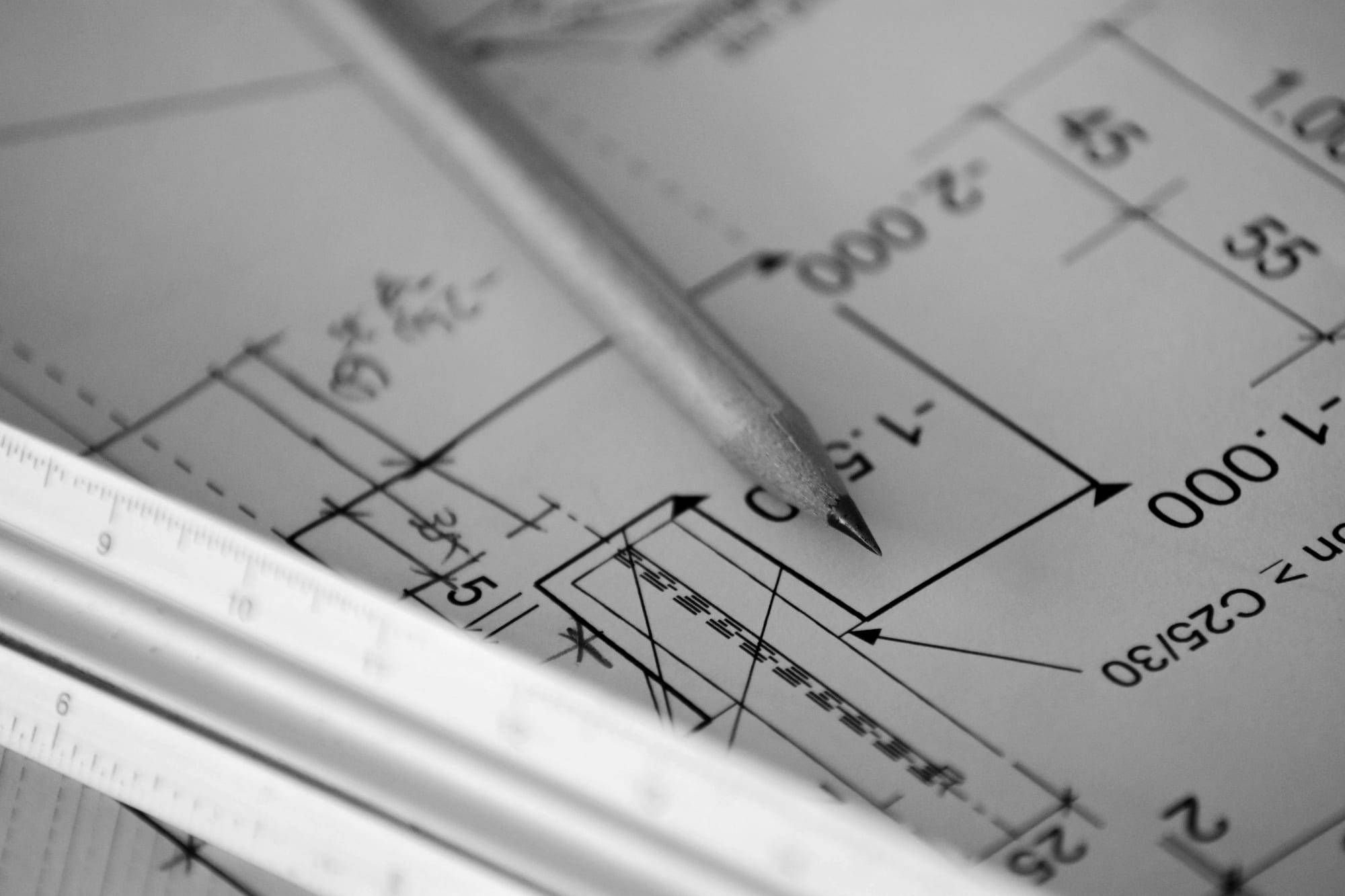 Pencil resting on printed architectural plans