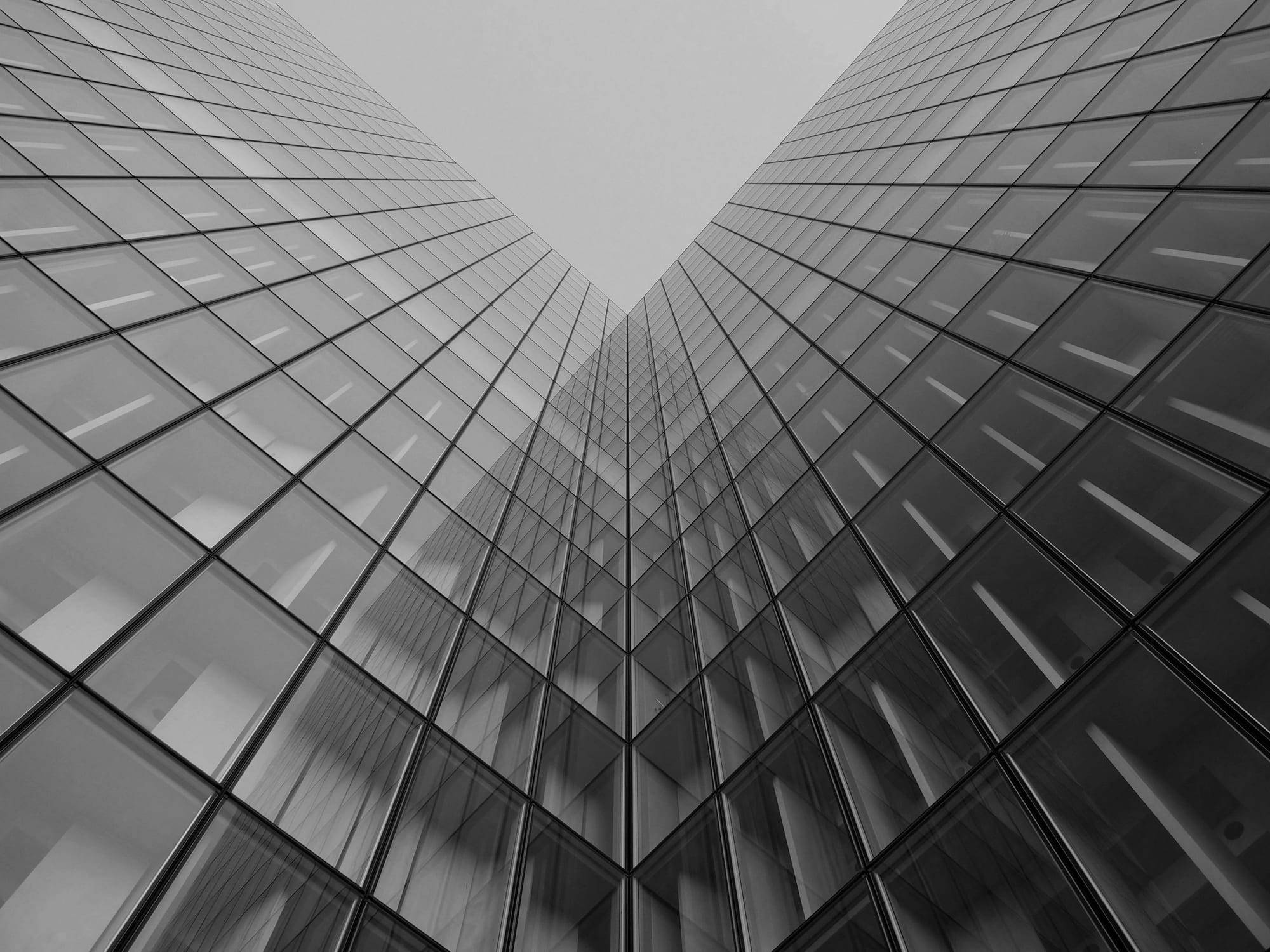 Glass office tower photographed from street level looking straight up